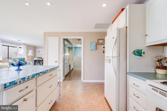 kitchen featuring white cabinets, dark countertops, ornamental molding, freestanding refrigerator, and recessed lighting