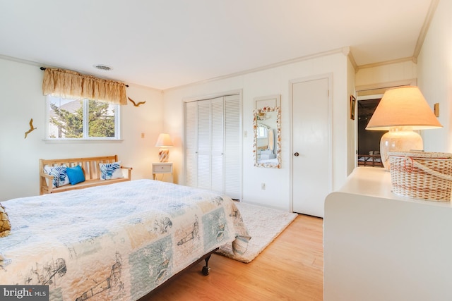 bedroom with light wood-type flooring and ornamental molding