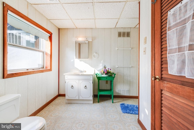 bathroom featuring a paneled ceiling, toilet, vanity, and tile patterned floors