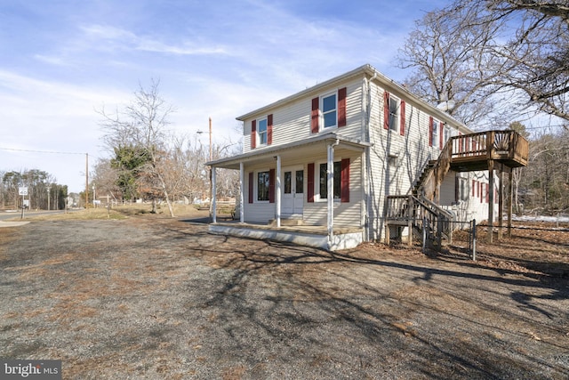 view of front of property featuring a porch, stairs, and fence