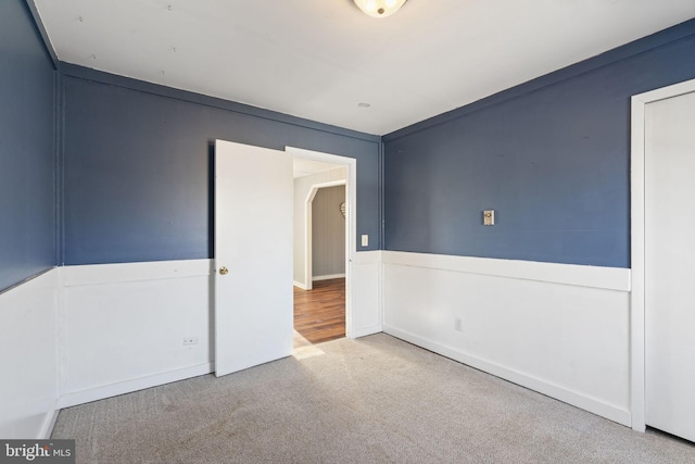 carpeted empty room featuring arched walkways