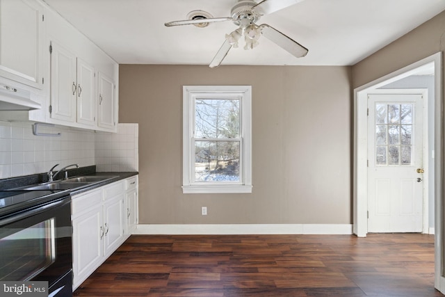 kitchen with a sink, white cabinetry, dark countertops, black electric range oven, and backsplash