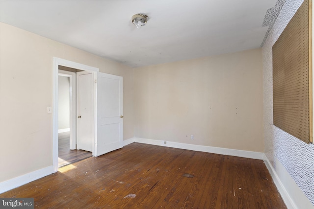 unfurnished room featuring baseboards and hardwood / wood-style floors