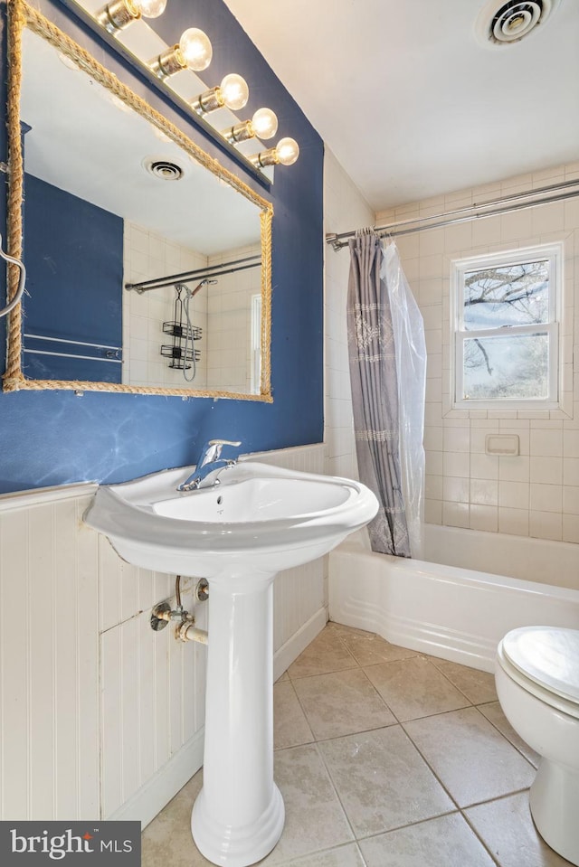 bathroom with visible vents, shower / bath combo with shower curtain, toilet, and tile patterned flooring