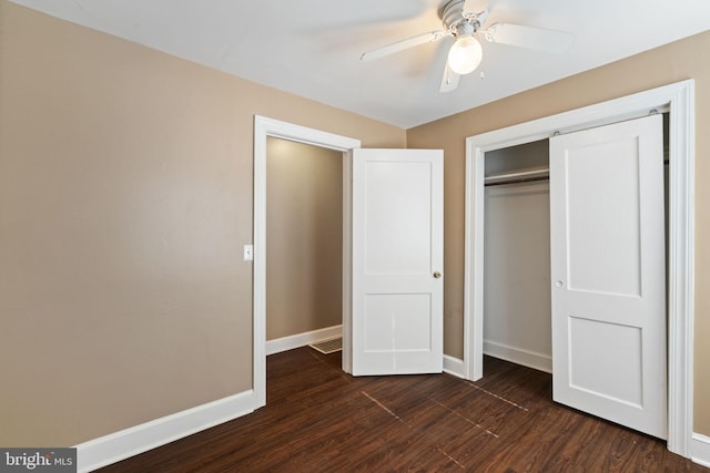 unfurnished bedroom with a ceiling fan, baseboards, dark wood-style flooring, and a closet