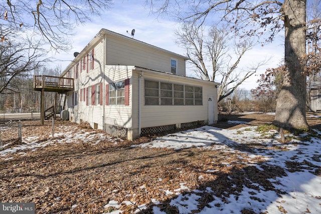 view of snowy exterior with a wooden deck