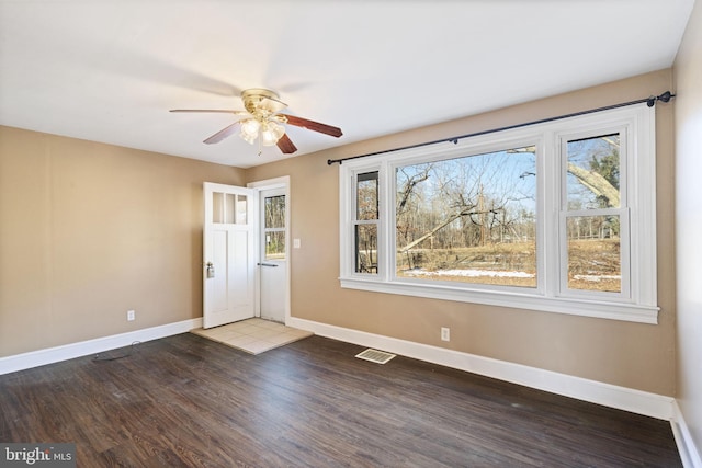 interior space with visible vents, baseboards, wood finished floors, and a ceiling fan