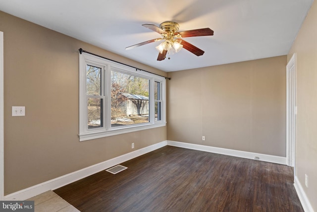 empty room with a ceiling fan, baseboards, visible vents, and dark wood-style flooring