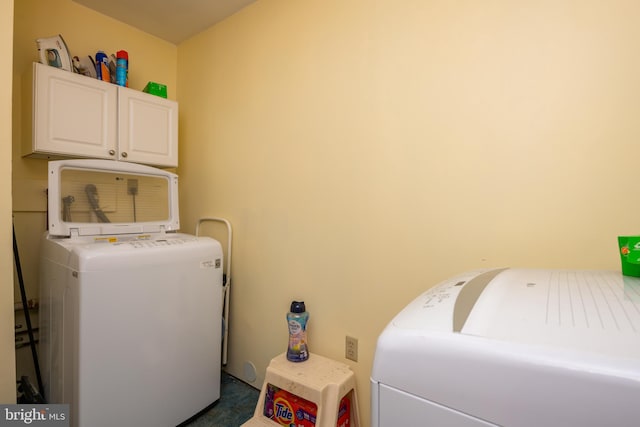 clothes washing area featuring cabinet space and separate washer and dryer