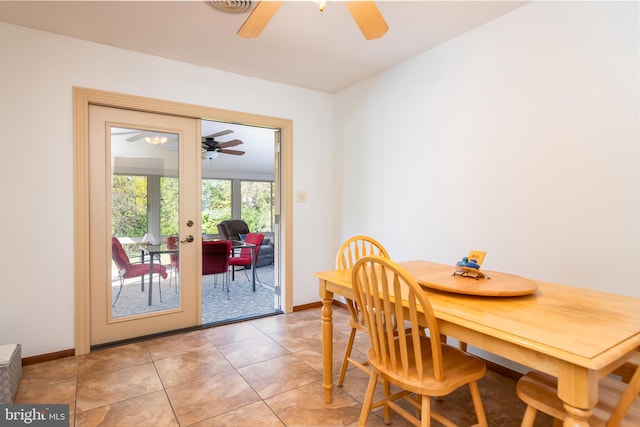 dining area featuring a ceiling fan, light tile patterned flooring, and baseboards