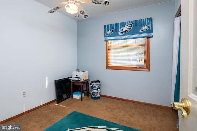 interior space featuring a ceiling fan, carpet flooring, and baseboards