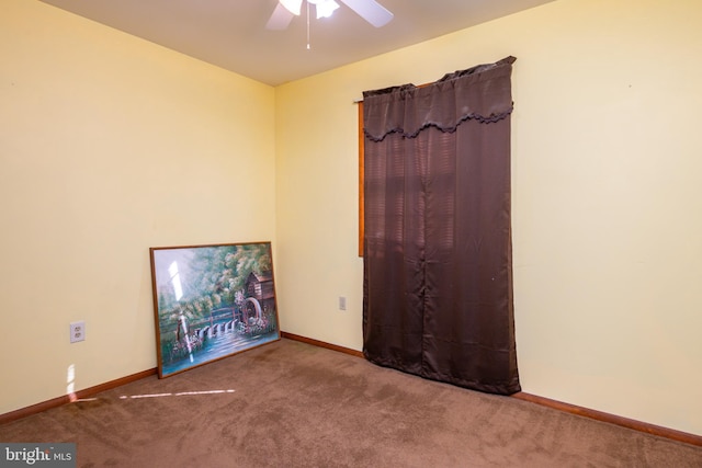 carpeted empty room featuring baseboards and a ceiling fan