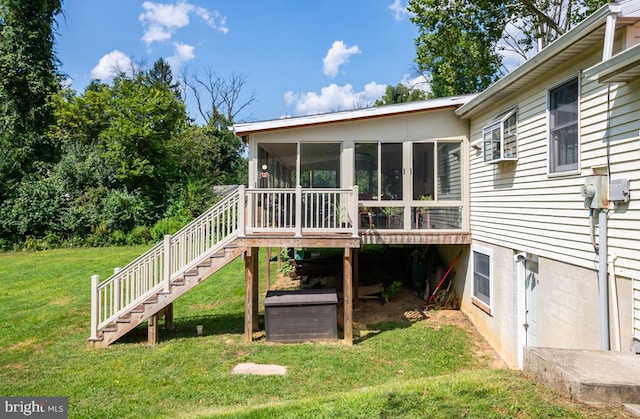 back of house featuring a sunroom, stairs, and a yard