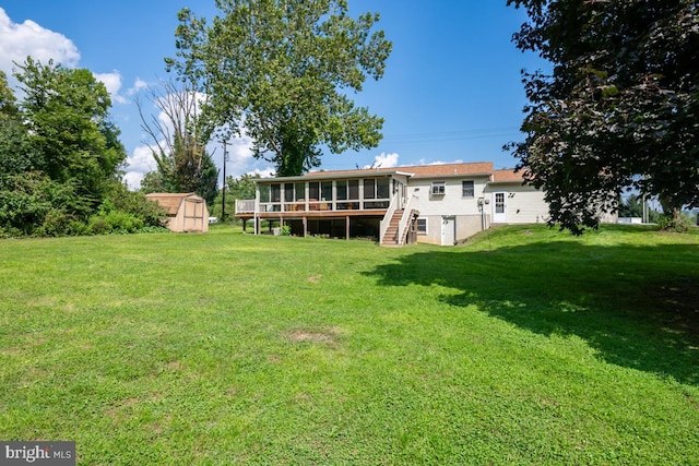 back of property with a shed, a yard, and a sunroom