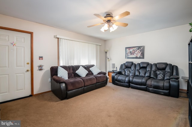 carpeted living area featuring a ceiling fan and baseboards