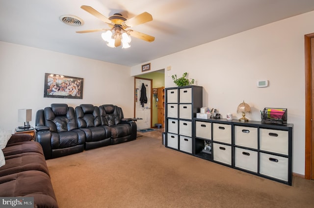 living room with carpet floors, visible vents, and a ceiling fan