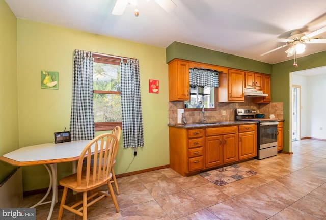 kitchen featuring decorative backsplash, a ceiling fan, a healthy amount of sunlight, stainless steel range with electric cooktop, and a sink