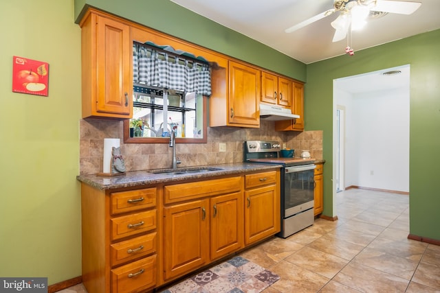 kitchen with dark countertops, decorative backsplash, stainless steel range with electric cooktop, a sink, and under cabinet range hood