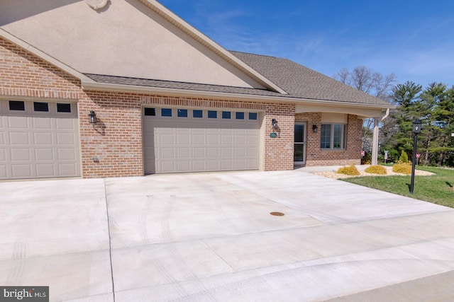 view of front of property featuring a garage, stucco siding, driveway, and brick siding