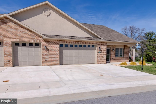 view of front of property with concrete driveway, brick siding, and an attached garage