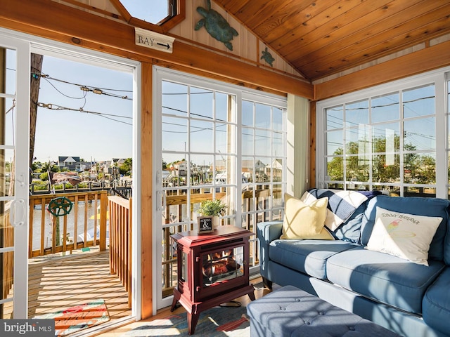 sunroom / solarium featuring wood ceiling, a wood stove, and vaulted ceiling