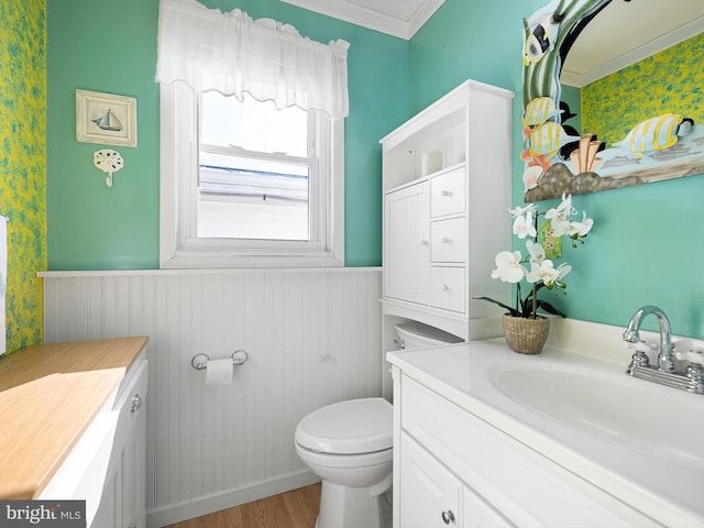 bathroom with vanity, toilet, ornamental molding, and hardwood / wood-style floors