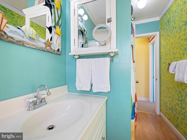 bathroom featuring ornamental molding, vanity, and hardwood / wood-style flooring