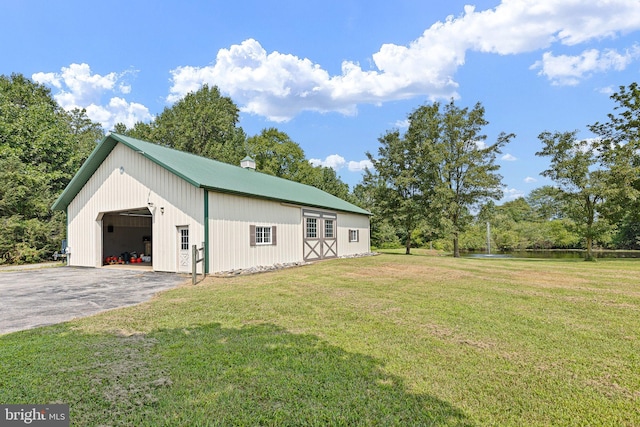 view of property exterior with a garage, an outbuilding, and a yard