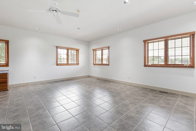 unfurnished room with tile patterned floors, plenty of natural light, and ceiling fan