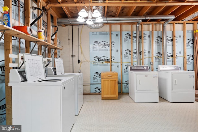 washroom featuring a notable chandelier and washing machine and dryer