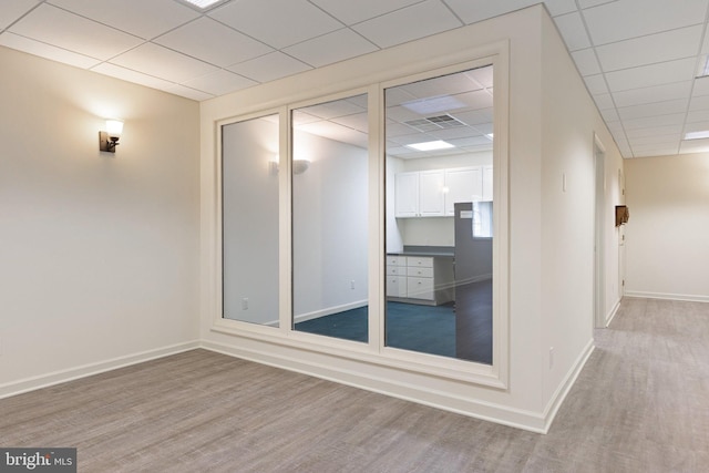 unfurnished room with hardwood / wood-style floors and a paneled ceiling