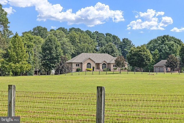 view of front facade featuring a rural view and a front lawn