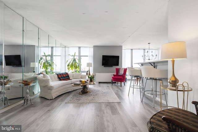 living room with a chandelier, floor to ceiling windows, and light hardwood / wood-style floors