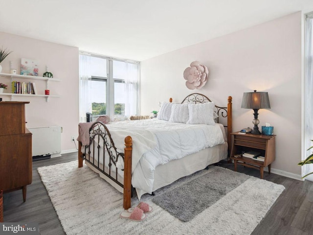 bedroom with dark wood-type flooring and radiator heating unit