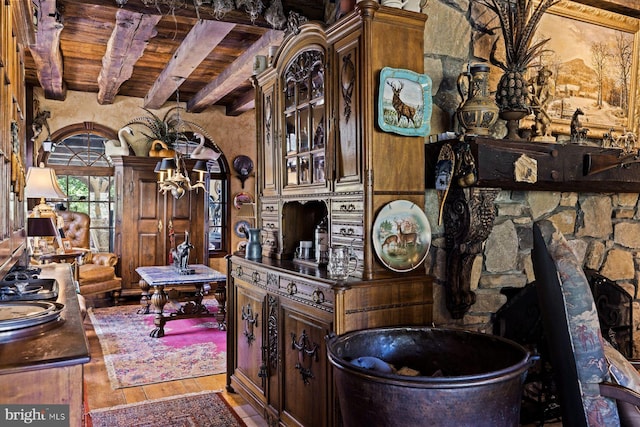 interior space featuring wood ceiling, beamed ceiling, wood-type flooring, and dark brown cabinets