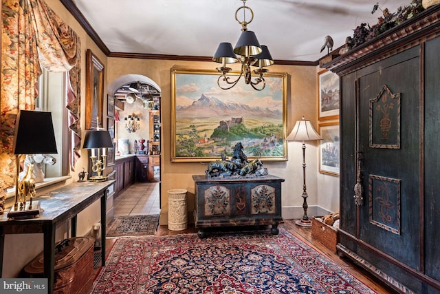 entrance foyer with hardwood / wood-style flooring, crown molding, and a chandelier