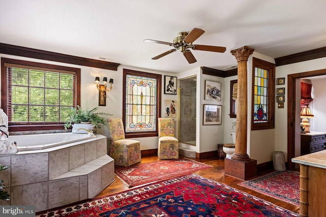 interior space with ceiling fan, hardwood / wood-style flooring, decorative columns, and ornamental molding