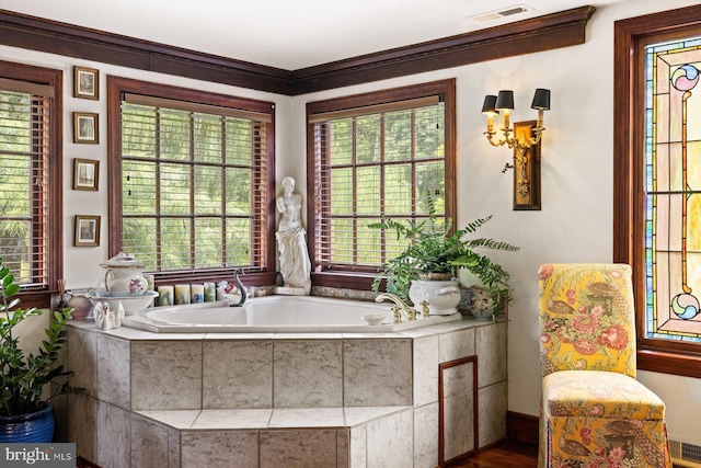 bathroom featuring tiled tub, hardwood / wood-style floors, and ornamental molding