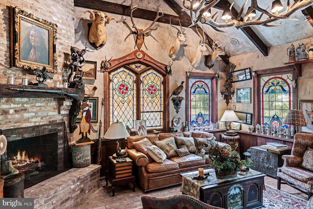 living room with beam ceiling, a chandelier, high vaulted ceiling, and a fireplace