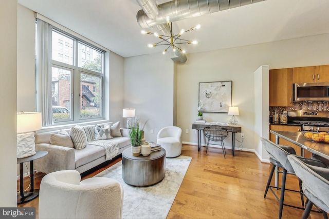 living room featuring light wood-type flooring and an inviting chandelier