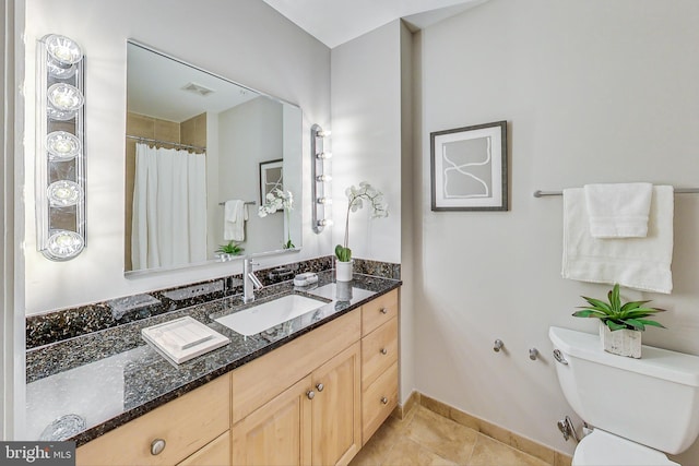 bathroom with tile patterned flooring, vanity, and toilet