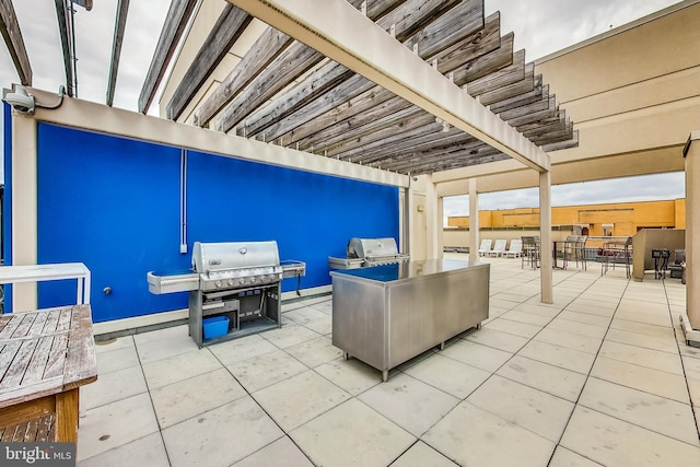 view of patio / terrace featuring exterior kitchen, a pergola, and area for grilling