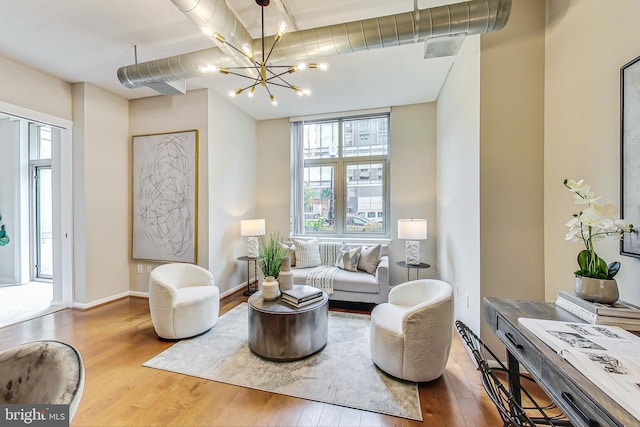 living room featuring light hardwood / wood-style floors, a notable chandelier, and a healthy amount of sunlight