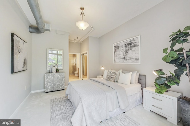 bedroom with light carpet and ensuite bath