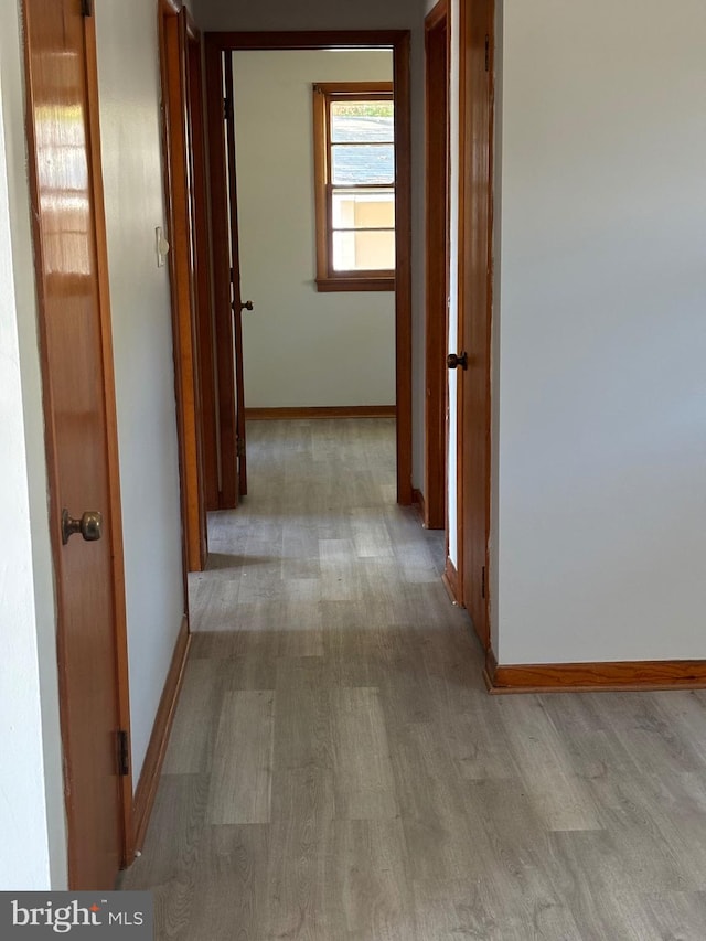 corridor with light hardwood / wood-style flooring