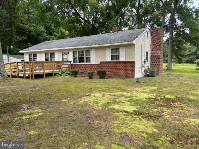 ranch-style home with a front lawn, a deck, and central AC unit