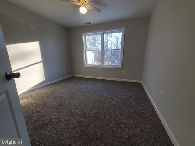 unfurnished room featuring dark colored carpet and ceiling fan