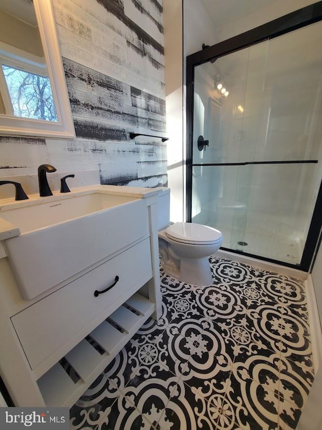 bathroom featuring tile patterned floors, vanity, an enclosed shower, and toilet