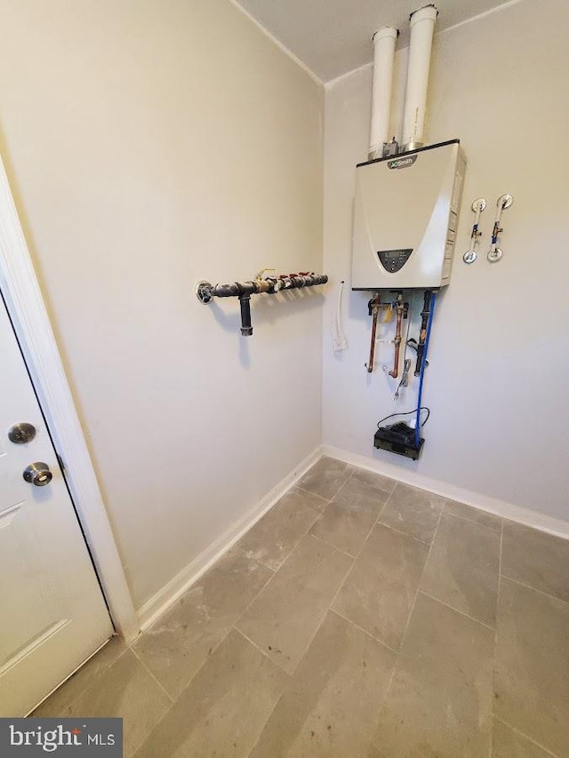 clothes washing area with water heater and baseboards
