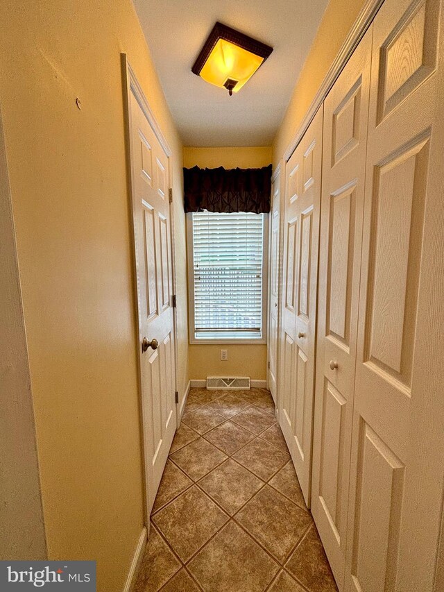 bathroom with tiled bath, tile walls, vanity, and tile patterned floors